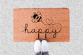 The Doormat District doormat with 'happy' text and bee design 