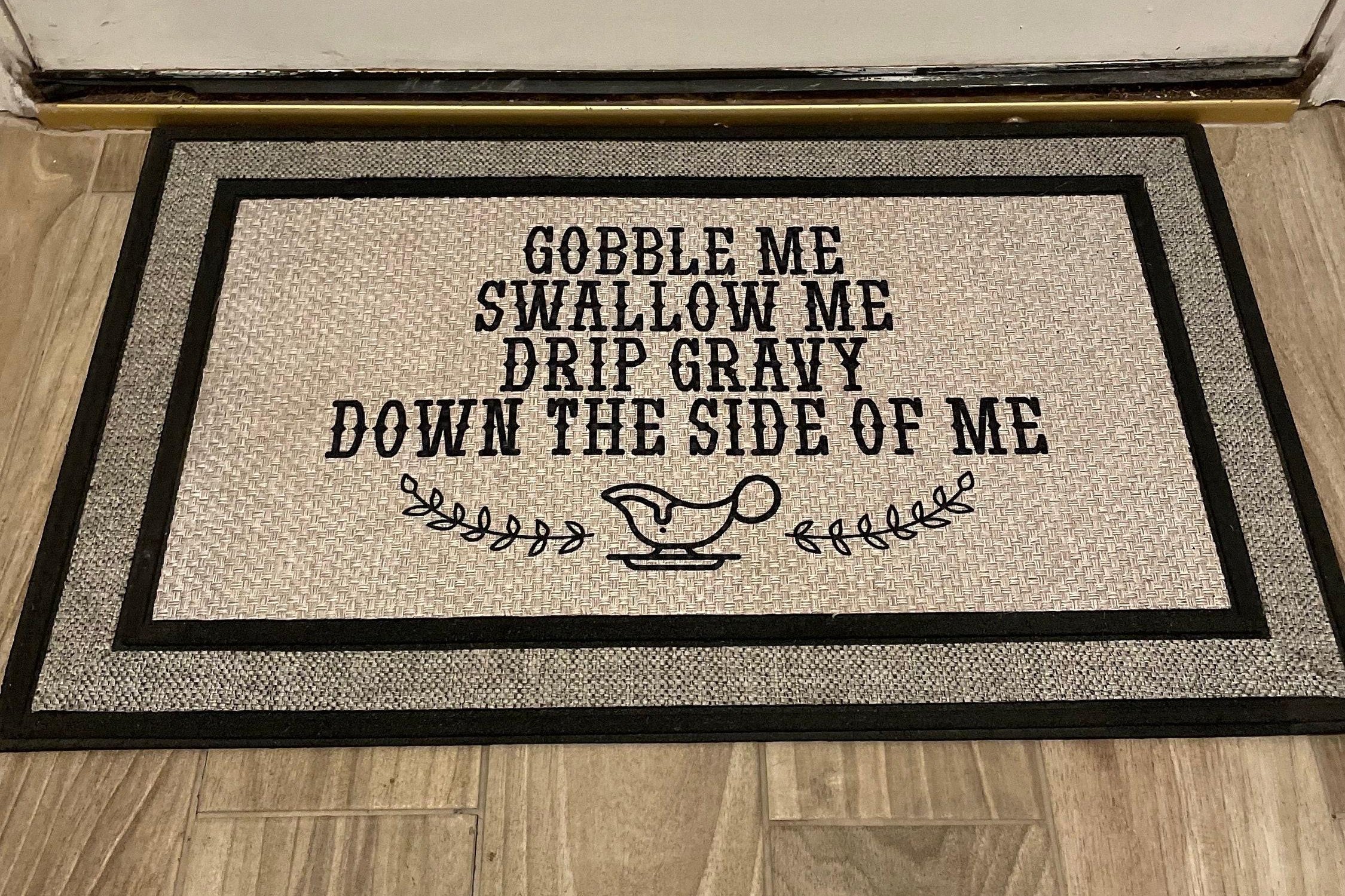 The Doormat District doormat with text "Gobble Me Swallow Me Drip Gravy Down The Side Of Me"