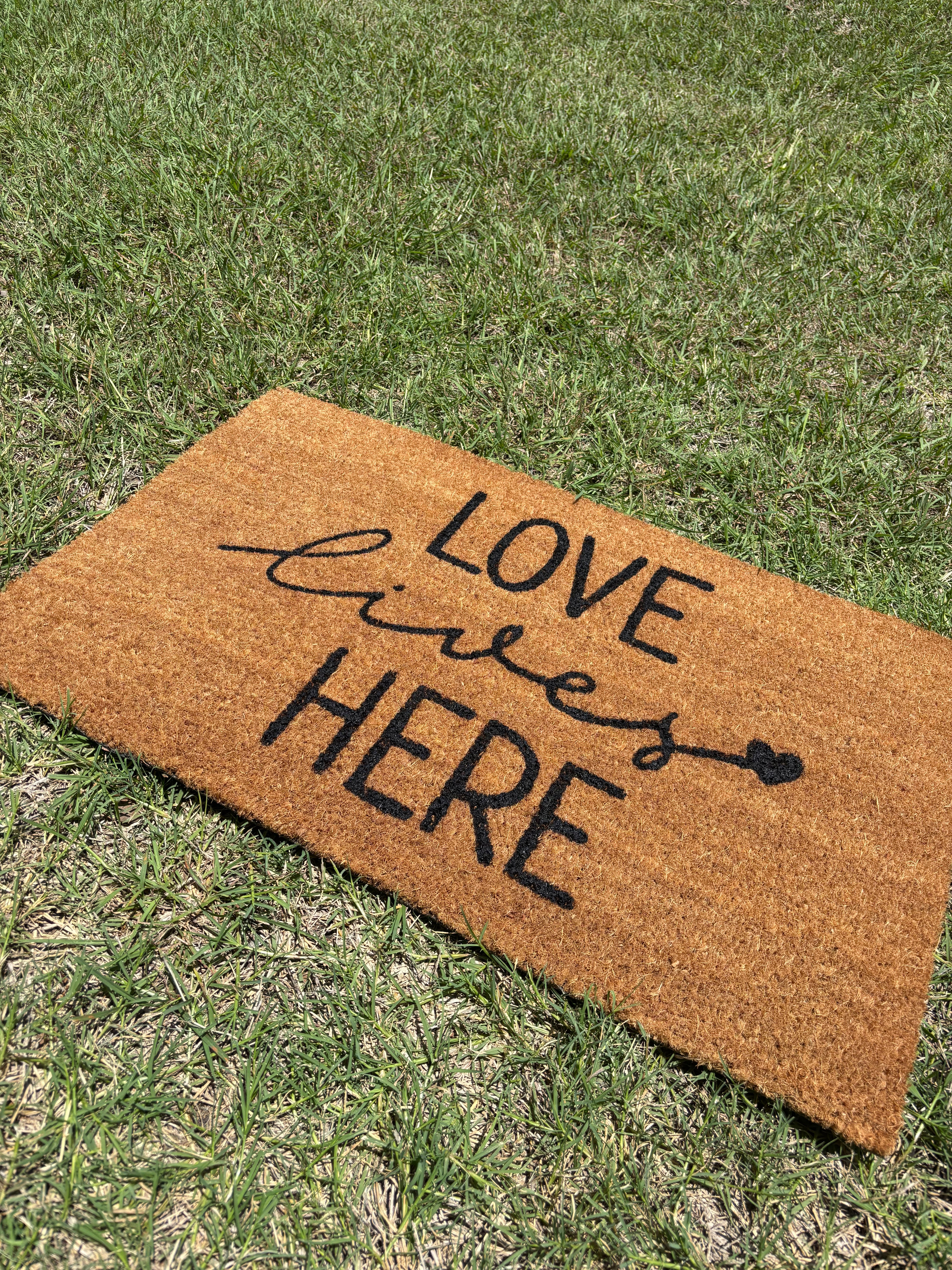 The Doormat District doormat with 'Love Lives Here' text 
