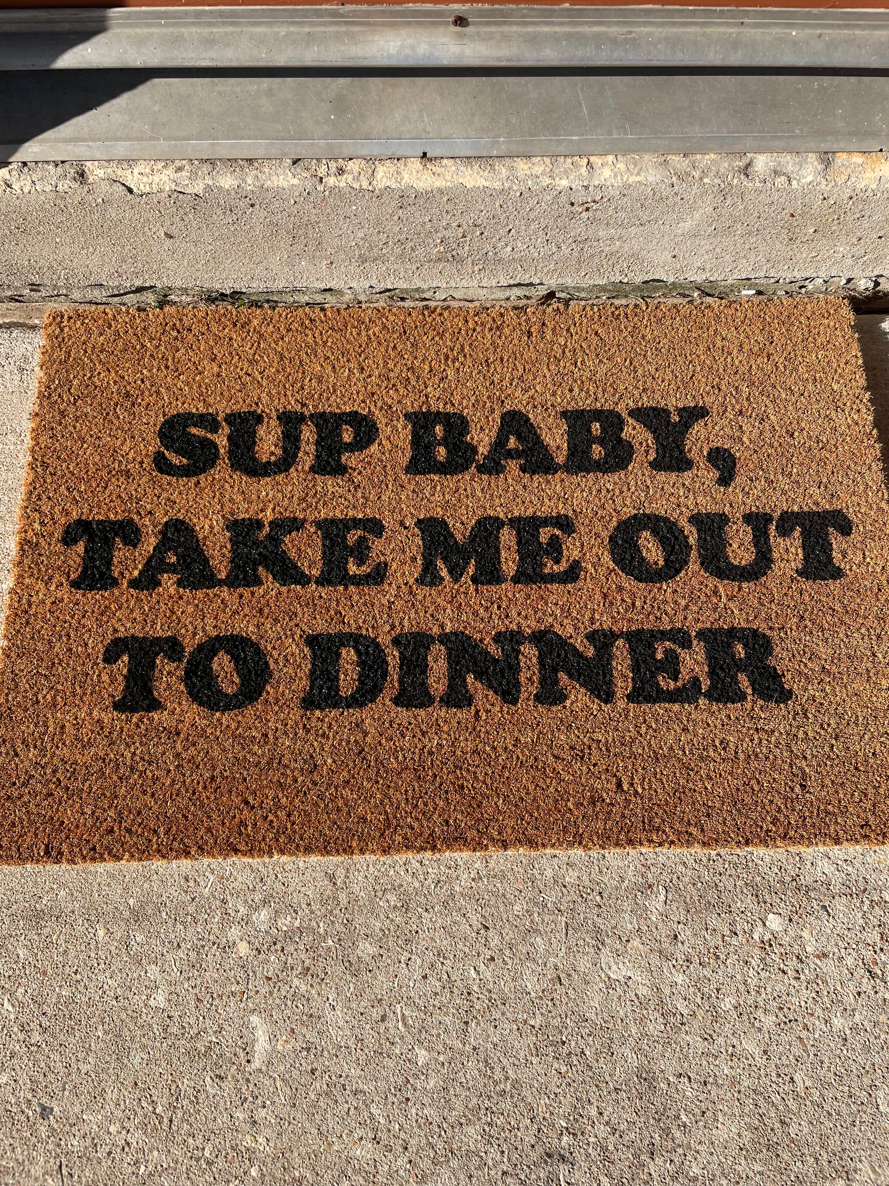 The Doormat District doormat with text "Sup Baby Take Me Out To Dinner"