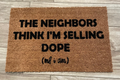 The Doormat District doormat with the quote The Neighbors Think I'm Selling Dope 