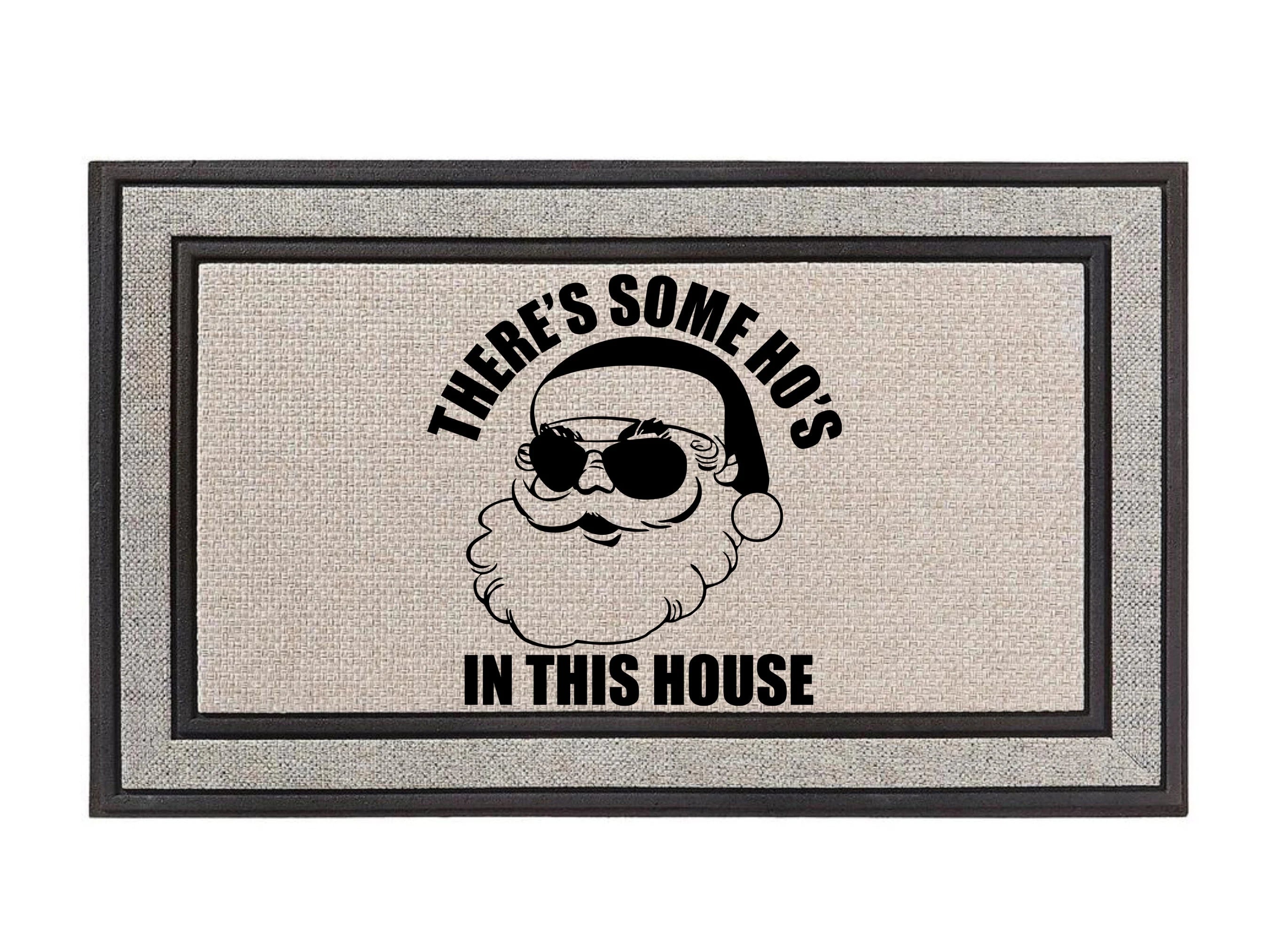 The Doormat District doormat with text 'THERE'S SOME HO'S IN THIS HOUSE' featuring a Santa Claus graphic.