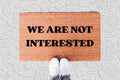 The Doormat District doormat with 'WE ARE NOT INTERESTED' text 