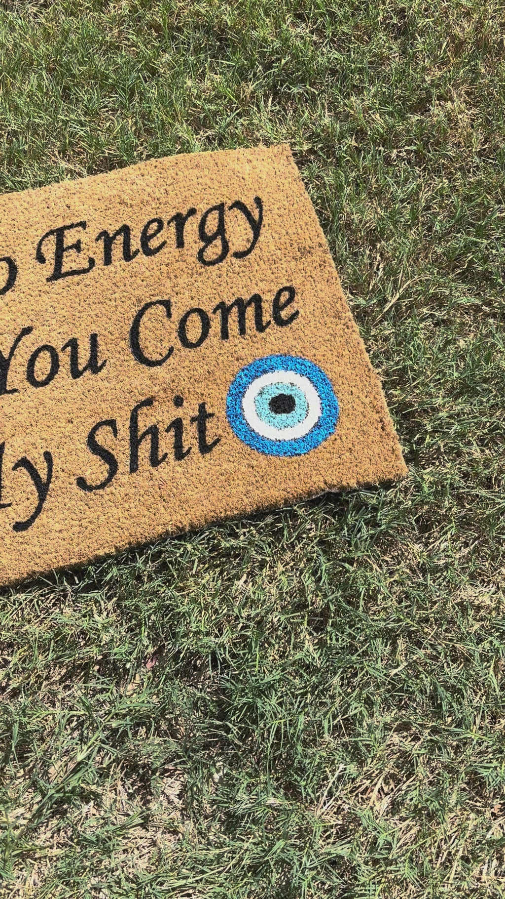 The Doormat District doormat with text "Check Yo Energy Before You Come In My Sht" with two blue evil eyes. 
