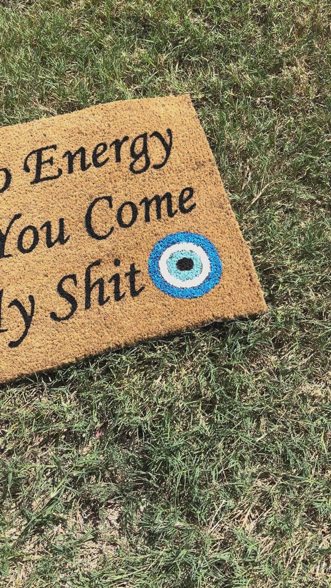The Doormat District doormat with text "Check Yo Energy Before You Come In My Sht" with two blue evil eyes. 